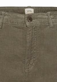 Olijfgroene corduroy broek met verticale ribbeltextuur, voorzien van een knoopsluiting en een label dat in de tailleband is genaaid.