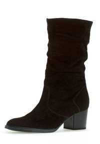 Svart mocka ankelsko med en slouchad design, rund tå och staplad klack. Har synliga sömmar och en slät textur.