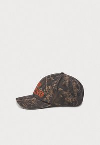 Schwarz-braune Kappe aus strukturiertem, gewaschenem Stoff, mit aufgesticktem orangem Logo und gebogenem Schirm. Verstellbarer Riemen hinten.