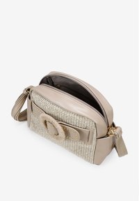Bolso de cuero beige y tejido trenzado con forma redondeada, presenta un cierre a torsión destacado, acentos dorados y una correa larga ajustable.