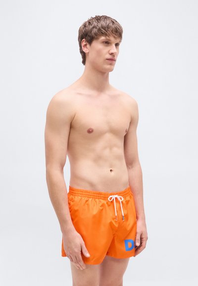 Πορτοκαλί μαγιό σορτς από ελαφρύ υλικό. Διαθέτει ελαστική μέση με λευκό κορδόνι και γαλάζια γραφική λεπτομέρεια.
