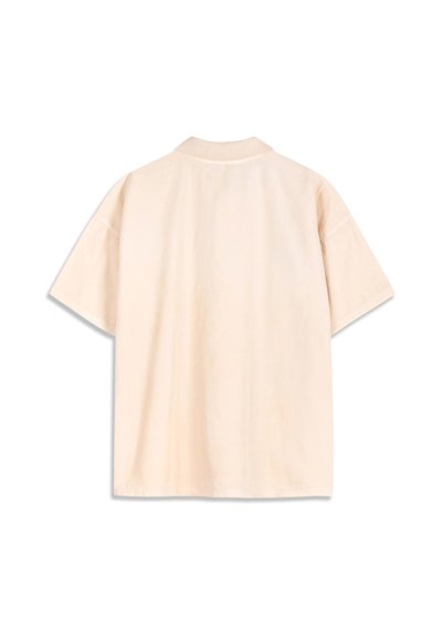 Polo beige à manches courtes vu de dos avec un col côtelé et une coupe ample et décontractée.