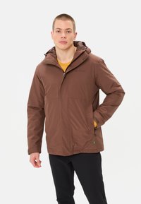 Veste imperméable marron avec capuche, fermeture éclair à l'avant et poches latérales. Fabriquée en tissu lisse, elle offre une coupe décontractée adaptée à une utilisation en extérieur.