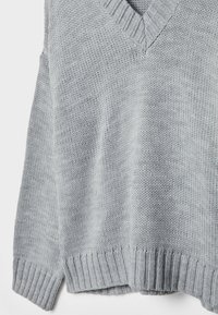 Grijze gebreide trui met een V-hals, geribbelde boorden en zoom. Heeft een losse pasvorm en een gestructureerd patroon.