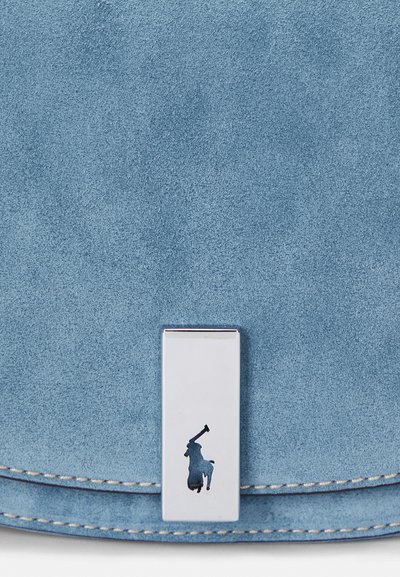 Svetlo modra zamškasta torbica z gladkim srebrnim pravokotnim zapiranjem, ki vsebuje logotip. Robovi so zaključeni z kontrastnim šivanjem.