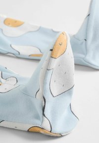 Bomullssockor i ljusblått med tecknade ägggrafik i vitt och gult. Har en mjuk textur och rundad tådesign.