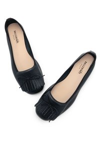 Black leather ballet flats with a rounded toe, textured upper, and a decorative bow on the front. Smooth beige interior lining.