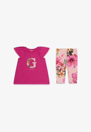 Robe rose pour tout-petit avec manches bouffantes et logo floral en forme de lettre G, accompagnée de leggings rose à motif floral.