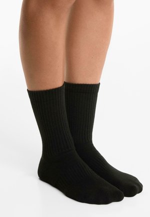 Svarta bomullssockor med ribbad struktur, knälängd, med en slät tådesign och elastisk topp för en säker passform.