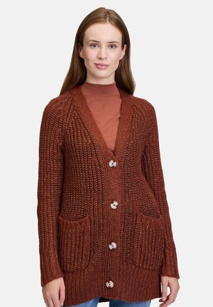 Knitted rust-colored cardigan with a deep V-neck, brown buttons, and two front pockets, featuring a ribbed texture and long sleeves.