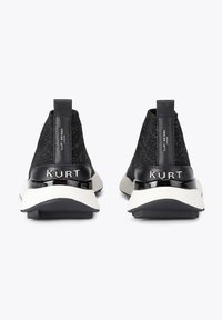 Czarne wysokie sneakersy z dzianiny, z błyszczącym czarnym akcentem na pięcie i białą podeszwą. Na pięcie znajduje się logo, a materiał jest teksturowany.