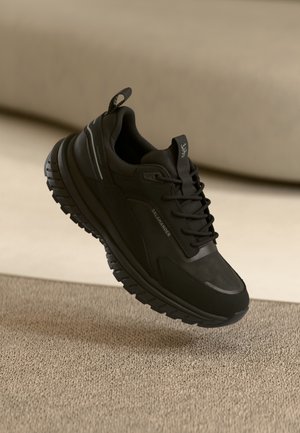 Črne atletske čevlje z teksturiranim, lahkim zgornjim delom, oblazinjenim srednjim delom in trdnim podplatom. Imajo diskretno blagovno znamko in odsevne poudarke.