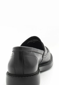 Chaussure en cuir noir avec une finition lisse, forme arrondie et accents cousus. Dispose d'un talon rembourré et d'une étiquette intérieure de marque.
