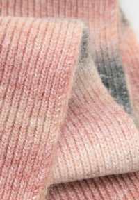 Tela de punto en tonos suaves de rosa y beige con una textura acanalada. Cambios sutiles de degradado a gris cerca del borde.