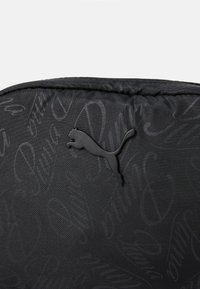 Black backpack with a textured pattern, featuring a prominent black Puma logo. Made from durable material with a smooth finish.