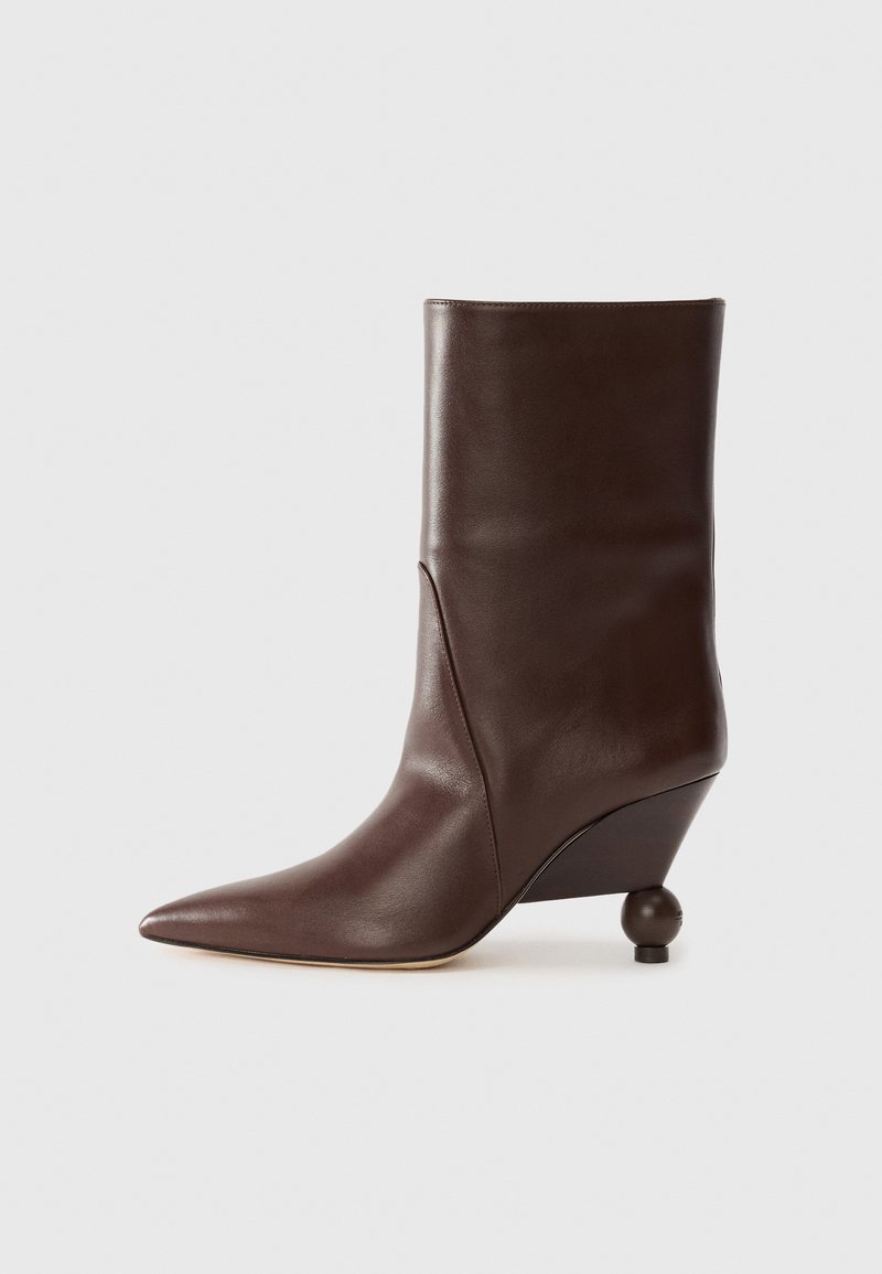Brown leather ankle boot with a pointed toe, tapered wedge heel, and rounded accent at the heel. Smooth texture and minimal seam detailing.