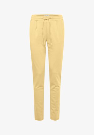 Jasnożółte spodnie dresowe wykonane z miękkiej mieszanki bawełny, z elastycznym paskiem w talii, sznurkiem do regulacji oraz bocznymi kieszeniami, w tapered fit.