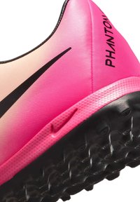 Nike Phantom soccer shoe features a gradient pink synthetic upper with a black swoosh and textured sole for traction.