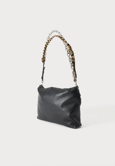 Sac à épaule en cuir noir avec une texture douce et une bandoulière combinant des maillons de chaîne argentés et un tissu tissé jaune et noir.