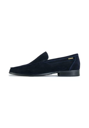 Navy blue suede men's loafer with low black sole and subtle stitching, side tag, and rounded toe design.