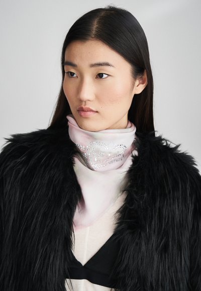 Μεταξωτό φουλάρι σε απαλό ροζ με διαβάθμιση, που παρουσιάζει ένα διακοσμητικό σχέδιο καρδιάς από κρύσταλλα, φορεμένο κάτω από μια μαύρη μιμή γούνας.