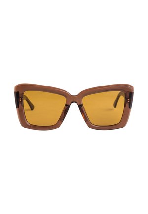 Bruine cat-eye zonnebril met gele lenzen en een dikke montuur. Kenmerken zijn scherpe hoeken en een glanzende afwerking aan de voorkant.