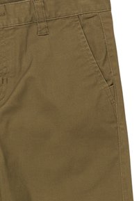 Chinos en coton vert olive avec une taille plate, des poches latérales et des détails de couture visibles. Texture lisse avec une coupe structurée.