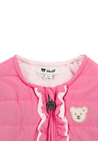 Růžová prošívaná dětská vesta s volánkovými detaily a vyšitým logem medvídka. Zapínání na zip s táhlem ve tvaru medvídka. Podšívka uvnitř.