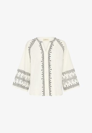 Blusa bianca con motivi ricamati neri, scollatura a V, chiusura frontale con bottoni e maniche campana a tre quarti. Tessuto leggero e testurizzato.