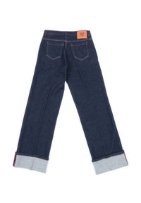 Jeans in denim blu scuro visti da dietro con risvolti e una patch in pelle marrone sopra la tasca destra.