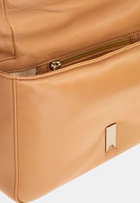 Heren leren handtas in een tan kleur met een gladde textuur, voorzien van een externe ritszak en een metalen accent aan de onderkant.
