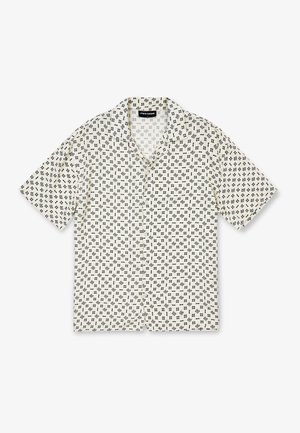 Koszula z krótkim rękawem zapinana na guziki, wykonana z beżowej tkaniny z powtarzającym się czarnym geometrycznym wzorem. Kołnierz z wycięciem, luźny krój i prosty dół.