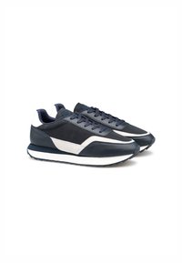 Scarpe da atletica blu navy con tomaia in pelle texture, suola intermedia bianca e accenti grigi. Presentano lacci piatti e un profilo snello.