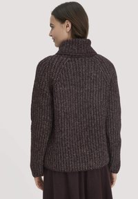 Dunkelpurpurfarbener, grob gestrickter Pullover mit hohem Kragen, gerippter Textur und lockerer Passform, ausgestattet mit Raglansäunen und einem geraden Saum.