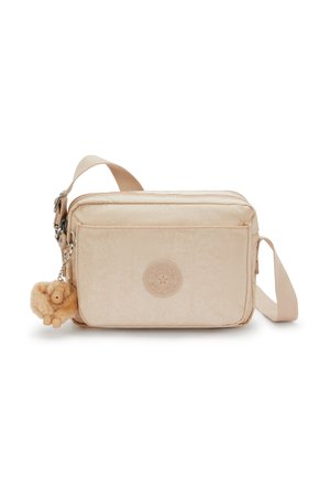 Borsa a tracolla color crema realizzata in materiale morbido, con logo rotondo, chiusure con zip e un portachiavi a forma di animale in peluche.