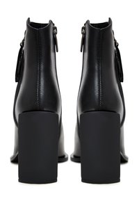 Stivaletti neri in pelle con tacco quadrato, chiusura con zip laterale e texture liscia. Presentano cuciture lungo il tallone per un tocco di dettaglio in più.