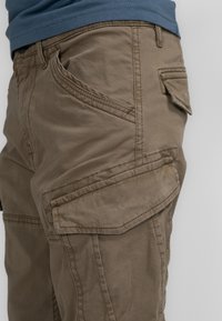 Khaki cargoshorts met meerdere zakken, zichtbare stiksels en een zachte, gestructureerde stof. Ontworpen voor functionaliteit met een relaxte pasvorm.