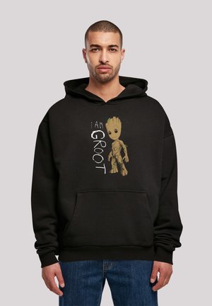Black hoodie with "I AM GROOT" text and graphic of a character with a brown, woody texture and green accents. Kangaroo pocket design.