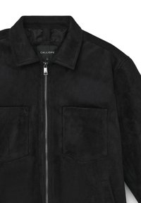 Giubbotto in suede nero con colletto piegato, zip anteriore, due tasche sul petto e etichetta della taglia contrassegnata "L" all'interno del colletto.