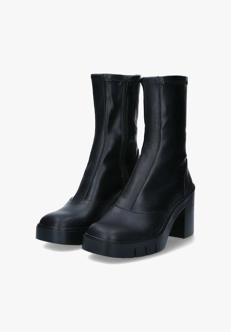 Botas de tobillo negras de cuero suave, con una suela gruesa y un tacón alto en bloque, con un cierre de cremallera lateral y detalles de costura mínimos.