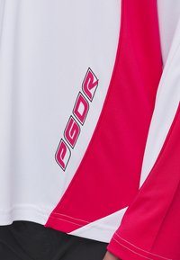 Športová košeľa s krátkym rukávom, biela s ružovými akcentmi, kontrastným stehom a čiernym logom "PGDR" na boku.