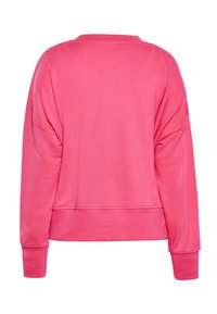 Felpa rosa oversize con scollo rotondo, maniche lunghe e polsini a costine. Tessuto liscio senza motivi o dettagli visibili.