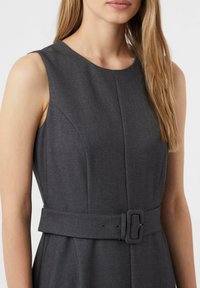 Szara sukienka bez rękawów o strukturalnym fasonie, z paskiem w talii, gładką tkaniną i detalami szwów wzdłuż biustu.
