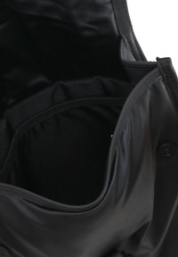 Borsa nera con un esterno liscio e lucido e un interno foderato in tessuto, caratterizzata da un'apertura arrotondata e una chiusura a scatto.
