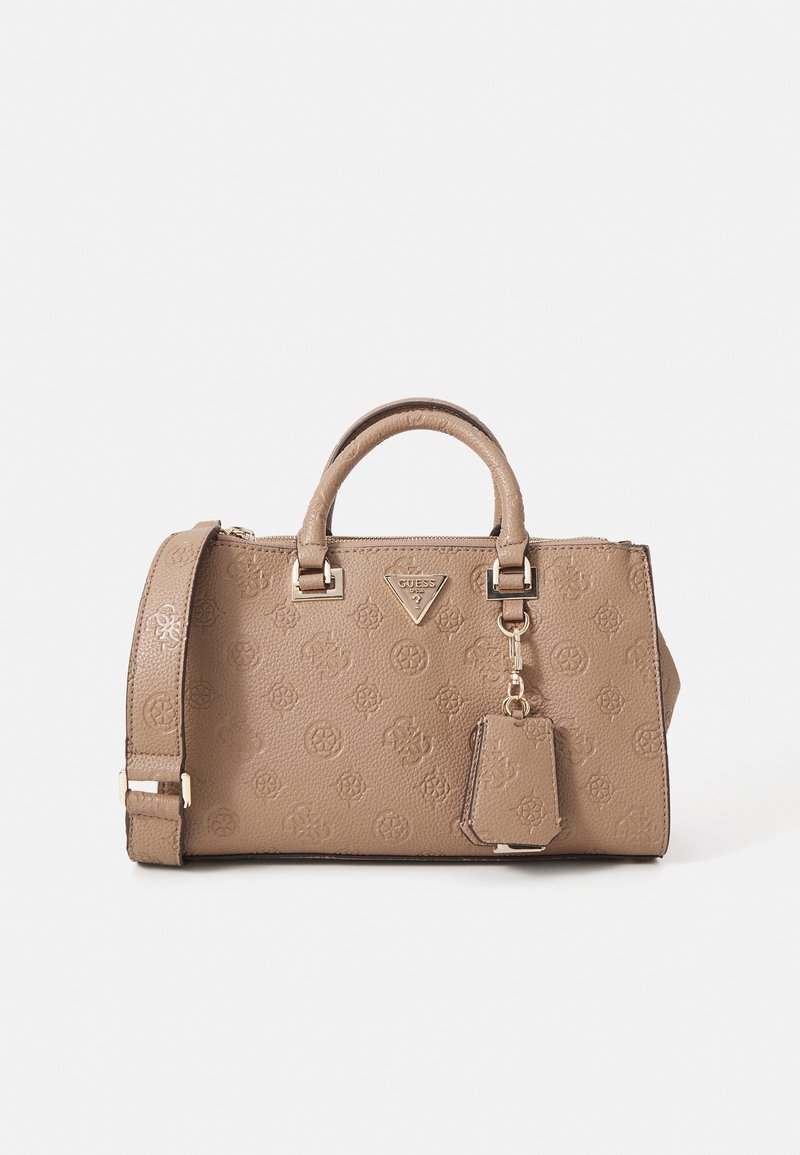 Sac à main beige Guess avec motif monogramme embossé, double poignée, bandoulière détachable et étiquette porte-clés attachée sur fond blanc.