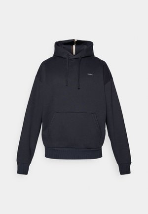 Kapuca majica v temno modri barvi, iz mešanice bombaža. Ima sprednji žep, rebraste manšete in rob, ter diskretno logo na prsih.