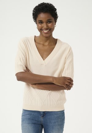 Pull en maille beige clair avec un col en V, des manches courtes bouffantes et un motif en losange texturé le long de l'ourlet et des manches.