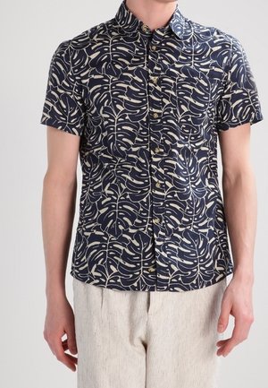 Chemise à manches courtes bleu marine avec un motif de feuilles blanches. Dotée d'un col boutonné et de cinq boutons à l'avant, fabriquée à partir d'un tissu léger.