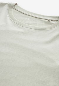 T-shirt corto grigio chiaro con maniche corte, realizzato in tessuto morbido e leggero. Presenta un collo rotondo e cuciture minime. Etichetta del marchio visibile all'interno.
