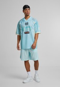 Karl Kani SIGNATURE TAPE - Tracksuit bottoms - lightaqua